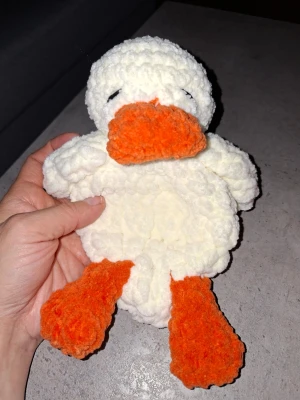 Virkad anka i mjukt garn - Söt handgjord anka i fluffigt vitt och orange garn. Den har stora orange fötter och näbb, samt broderade ögon. Perfekt som dekoration eller gosedjur. Unik och mysig present till någon som gillar gulliga saker. Passar perfekt till småbarn och babysar.