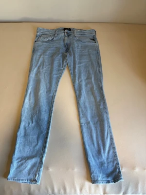 Ljusblå slimfit jeans från Replay  - Säljer ett par ljusblå jeans från Replay med slim fit. Perfekta för en avslappnad och stilren look.