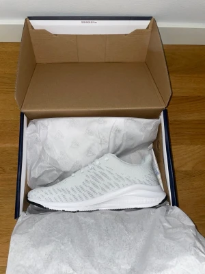 Vita sneakers  - Fräscha vita sneakers. Skorna har en sportig och modern design med vita skosnören och en bekväm, lätt sula. Perfekta för träning, promenader och vardagligt 
