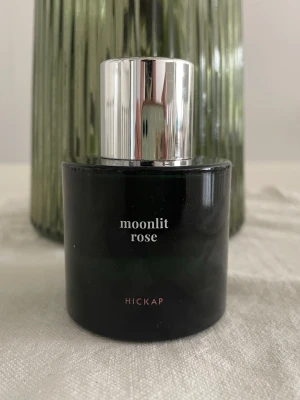 Moonlit Rose - Parfym från Hickap i Limited Edition. Doftfamilj: blommig/orientalisk. Toppnoter: jasmin, ros, vanilj, cederträ. Hjärtnoter: sandelträ, mysk, kanderad frukt. Basnoter: freesia, liljekonvalj, patchouli. Mer än hälften kvar i flaskan. 