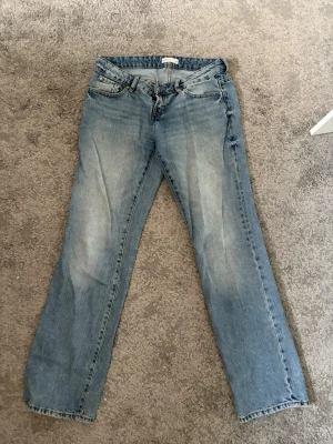 Ljusblå jeans - Säljer ett par ljusblå jeans från Gina tricot med rak passform, super trendiga jeans!! Jeansen har slitningar och tvättade detaljer för en avslappnad look. Nypris 500