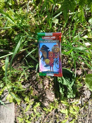 LAMINCARD Italian Brainrot booster - LAMINCARD Italian Brainrot boosterpack från Multiverse. Förpackningen är färgglad i rött, grönt och silver med tecknade figurer på framsidan. Perfekt för samlare av trading cards eller dig som gillar unika kortspel.