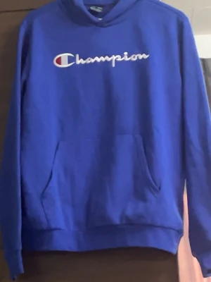 Blå hoodie från Champion - 176-179 cm. Hoodie 15-16 år. Ingen användning för liten!