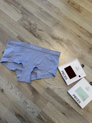3par boxertrosa från Pieces - Säljer en ljusblå, vinröda och gröna boxertrosa från Pieces med bred resår i midjan där märket står tryckt. Trosan har en mjuk och stretchig passform och är tillverkad i ett tunt, bekvämt material. Perfekt för dig som gillar en sportig och enkel stil. Två extra förpackningar i vinrött och mintgrönt medföljer. Nypris 79kr, 99kr, 99kr 