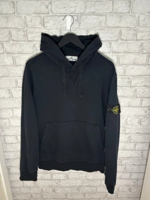 Stone Island hoodie - Stone Island hoodie i svart färg. Klassisk och clean modell med badge på armen och skön passform. Väldigt bra skick och enkel att matcha.