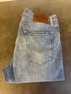Ljusblå jeans från Replay stl 32/33 - Säljer ett par ljusblå jeans från Replay med klassisk femficksmodell och snygga kontrastsömmar på bakfickan. Jeansen har normal midja och raka ben. Tillverkade i mjukt denimtyg som ger en avslappnad look.