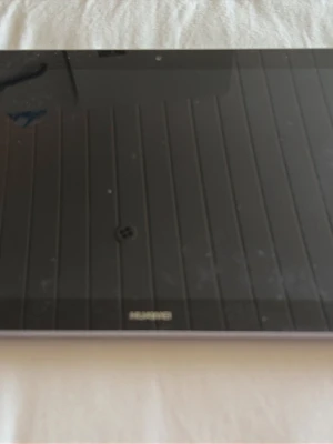 Huawei bärbar ipad i silver - Snygg och tunn bärbar dator från Huawei i stilren silverfärg. Datorn har en stor skärm med svart ram och ett metallchassi som ger en modern känsla. Perfekt för studier, surf och streaming.