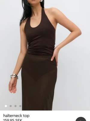 Brun halterneck sommartopp - Snygg brun halterneck topp från Gina trixig med tight passform och ärmlös design som är perfekt för sommaren.