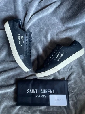 Svarta Saint Laurent sneakers - Svarta sneakers från Saint Laurent. 10/10 skick, enbart testade men säljer då de inte passade mig. Kan gå ner i pris vid snabb affär!