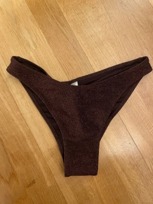 Bikinitrosor - Bikinitrosor från Lindex i storlek M. Använda 1 gång. Brun/glittriga.