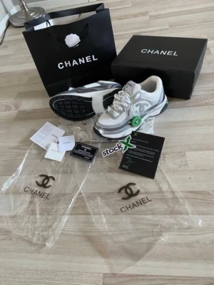 Vita Chanel sneakers med silverdetaljer - Säljer ett par skor, alldrig använda, helt nya, priset kan diskuteras, fråga gärna om mer bilder!