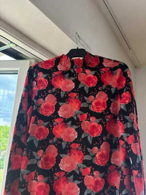 Blus Pieces - Svart blus med röda rosor från Pieces i storlek S!