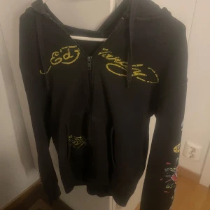 Svart Ed Hardy x Urban Outfitters hoodie - Svart hoodie med dragkedja från Ed Hardy x Urban Outfitters. Klippt av snören