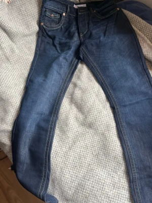 Mörkblå raka jeans med kontrastsömmar - Säljer ett par mörkblå jeans med raka ben och en gnutta 70-tals dansband form i flaren av jeansen  plus tydliga kontrastsömmar. Detta är ett par Unisex Jeans, perfekt för dig med lite pondus i stilen och vågar visa vad du Tycker och Tänker, Dom är hyfsat populära bland Archive stilen men fortfarande ny och unik inom bärarna av stilen . Hör av dig vid minsta fundering
