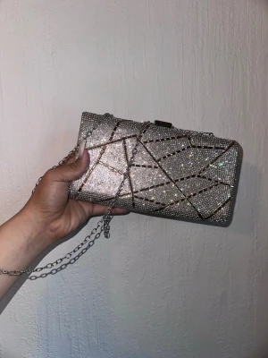 Clutch bag with sling - This is a very shiny bag with really cool details! worn once. there’s no issue just that the down part went out a little but can barely seen! promise!  that is the style so it not broken