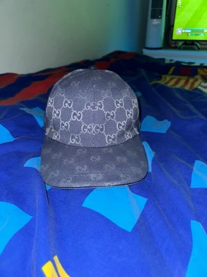 Blå keps med gg mönster - Säljer en blå keps, märket ser ni själva meddelar det klassiska märkes monogrammet över hela kepsen. Kepsen har böjd skärm och är tillverkad i ett slitstarkt tygmaterial. Perfekt för dig som vill ha en stilren och lyxig accessoar till din outfit. ///// PRIS KAN DISKUTERAS, SKRIV FÖR FLER BILDER