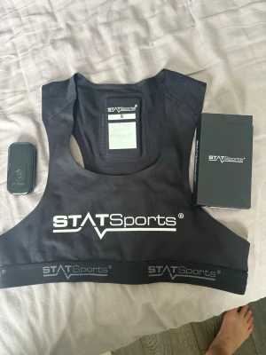 STATSports pulsmätarväst med sensor - Pulsmätarväst från STATSports i svart, storlek S. Västen är tillverkad i stretchigt och ventilerande material och har tydlig logga framtill. Medföljer pulssensor och originalförpackning. Perfekt för träning och sport där du vill ha koll på din puls och prestation. Finns kvitto och allt. Skriv vid info. Nytt pris: 3115