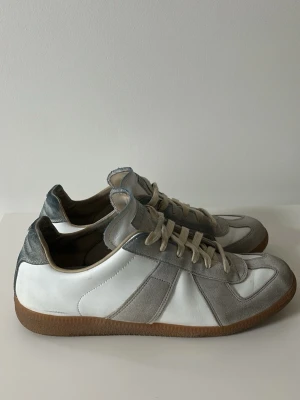 Maison Margiela Gats Skor - Klassiska Maison Margiela GATs i vit och beige colorway. Välanvända med naturligt slitage. Kan finnas några blå märken från selvedge-jeans som jag kan ha missat vid rengöring. Skicket är som på bilderna. OBS SKORNA VAR BLÖTA PÅ BILDERNA PGA RENGÖRING Skick: 8/10 Pris kan diskuteras 📦 Skickas eller möts upp