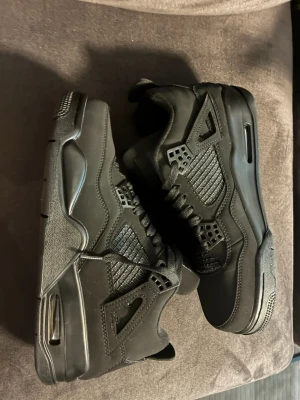 Svarta Air Jordan 4 Black Cats sneakers - Säljer ett par hel nya svarta Air Jordan 4 Black Cats sneakers
