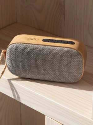 SACKit Go Wood 300 S högtalare - Snygg bärbar Bluetooth-högtalare från SACKit i modellen Go Wood 300 S. Högtalaren har en naturlig träfinish och framsida i grått tyg. Den är rektangulär med rundade hörn och har smidiga knappar på ovansidan samt en praktisk snodd för enkel transport.