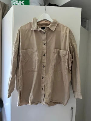 Beige skjorta med fickor - En rejäl beige oversize skjorta med fickor