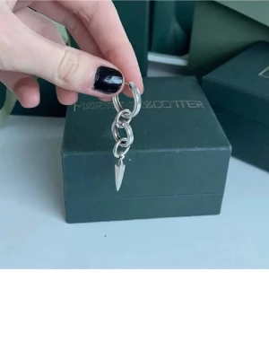 Silverörhänge från Maria Nilsdotter - Säljer ett coolt silverörhänge från Maria Nilsdotter med flera sammanlänkade ringar och en spetsig hängande detalj. Örhänget har en modern design i silver. Örhänget har inte använts mycket, men behöver silverputsas lite🌸 nypris 2795