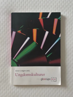Ungdomskulturer av Simon Lindgren - Boken 'Ungdomskulturer' av Simon Lindgren (red.) utforskar svensk ungdomsforskning och identitetsskapande bland unga. Omslaget har färgstarka grafiska former mot svart bakgrund och boken är i mjukt, matt papper. Perfekt för dig som vill förstå dagens ungdomar. En sida med ytterst lite blyerts men ingenting som stör texten eller själva läsningen. Bra skick annars! 🌸