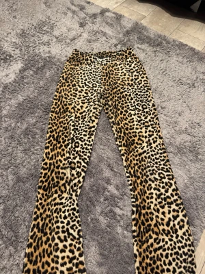 Leopardmönstrade leggings Gina Tricot - Säljer ett par leopardmönstrade leggings från Gina Tricot i storlek XS. De är i stretchigt material med 95% polyester och 5% elastan. Tight passform och hög midja, perfekta för dig som vill sticka ut med ett djuriskt mönster.