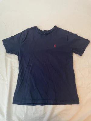 Marinblå t-shirt från Ralph Lauren - Säljer nu min Ralph lauren T-shirt så den är för liten för mig. Storkelen är väldigt svår att tyda men det jag ser står det 140/68. Priset kan diskuteras vid snabb affär 