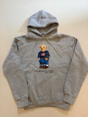 Ralph Lauren Polo Björn hoodie - Grå Ralph Lauren polo bear hoodie // 10/10 skick aldrig använd // storlek S // längd 59cm axelbredd 48cm armlängd 57cm // skriv vid minsta fråga eller fundering🤝