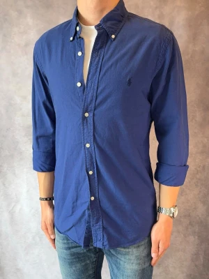 Mörkblå Ralph Lauren Skjorta - Stl M, Slim fit - Riktig snygg Ralph Lauren Skjorta, perfekt till sommaren! 🏖️🌊 | Mycket bra skick: 9,5/10, utan defekter  | Stl: M |  Modellen är 177cm och väger 74kg | Billigare pris vid köp av bundle 😉Hör av dig vid frågor // Galgen 🫡 