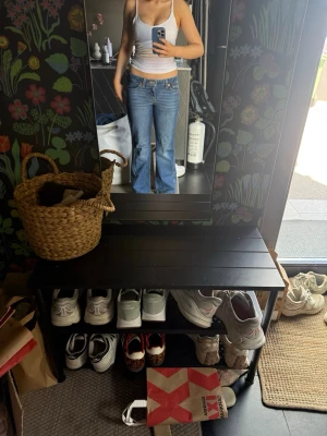 Blå lågmidjade bootcut jeans från Levis  - Säljer ett par klassiska blå bootcut jeans från Levis med låg midja och femficksmodell. De är knappt använda då de var lite för stora för mig. Jeansen har snygga detaljer på bakfickorna och är tillverkade i denim med lätt stretch för skön passform. Perfekta för en avslappnad och trendig look.