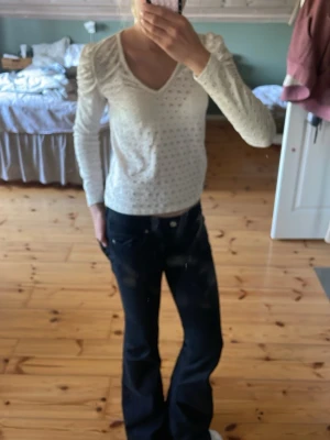 Vit spets blus med v-ringning - Snygg vit blus med v-ringning och långa ärmar. Perfekt att styla med jeans eller kjol för en cool vardagsstil.
