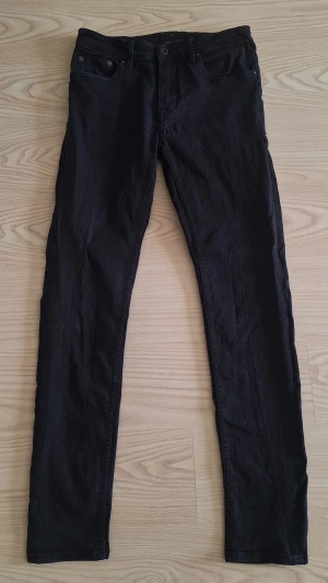 Svarta skinny jeans från JUNK de LUXE W31 L32 - Säljer ett par svarta skinny jeans från JUNK de LUXE, J-01. Jeansen har klassisk femficksdesign, smal passform och är tillverkade i stretchigt denimtyg för extra komfort. Perfekta för dig som gillar en stilren och enkel look.