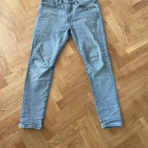 Levi's 512 ljusgrå jeans - Säljer ett par ljusgrå Levi's 512 jeans med klassisk femficksdesign och slim fit. Jeansen har normal passform och är tillverkade i denim. Perfekta för dig som gillar en stilren och tidlös look.