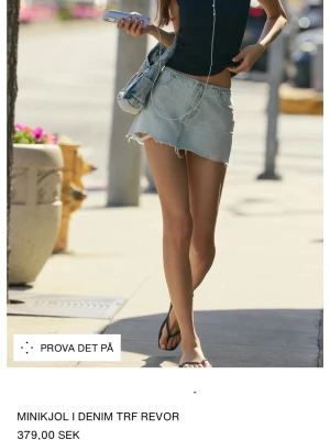 Ljusblå denim minikjol med slitna detaljer - Trendig ljusblå minikjol i denim från TRF med råa, slitna kanter och revor. Kjolen har klassisk femficksdesign och en avslappnad passform. Perfekt för dig som gillar en edgy och avslappnad stil. Helt ny storlek M