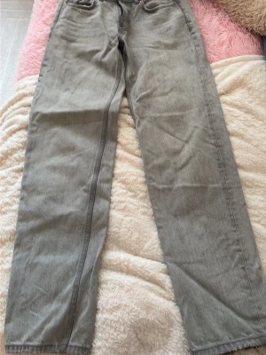 Grå raka lågmidjade  jeans från gina tricot  - Snygga grå jeans med rak passform från g perfect jeans. Klassisk femficksmodell och normal midja. Jeansen är tillverkade i ett mjukt denimtyg som ger en avslappnad look. Perfekta för dig som gillar stilrena och enkla plagg.