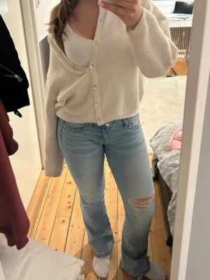Ljusblå bootcut jeans med slitning - Säljer ett par ljusblå bootcut jeans med slitning på ena låret och lätt utsvängda ben. Är i storlek 36 men passar både 34 och 38 då de har stretch material! Hör av er för frågor🥰