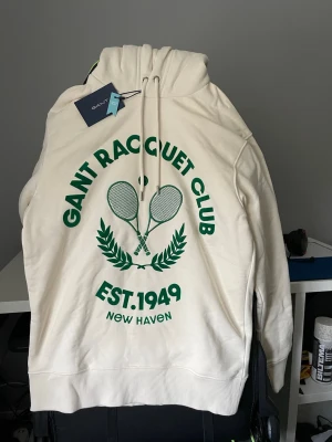 Gant hoodie racquet club - Vit/creme hoodie från Gant, oanvänd med prislapp kvar. Storlek S 