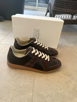 Maison Margiela Replica sneakers brun - KVITTO FINNS. Tveka inte med att ställa frågor. Pris kan diskuteras vid snabb affär. Dem är använda vid ett tillfälle men är i princip i nytt skick.