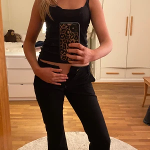Svarta lågmidjade kostymbyxor från BikBok - Snygga svarta byxor från BikBok i storlek 34. De har en stilren design med en rak passform och liten slits längst ner på benen. Byxorna har en diskret dragkedja och knappar framtill. De är storlek 34 men jag skulle säga att de sitter som en 32, passar mindre storlekar också. Midjemått - 32cm tvärs över, innerbenslängd - 77cm. Tryck inte på köp nu.💞kontakta om du har någon fråga.