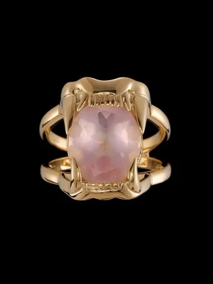Maria Nilsdotter ring  - Cool ring i guldfärgad metall med en stor, facetterad rosa sten i mitten. Ringen har ett unikt designinslag med kloliknande detaljer som håller stenen på plats. Perfekt för dig som gillar statement-smycken och vill sticka ut.