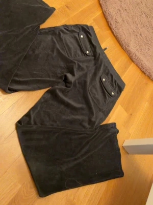 Svarta juicy byxor - Svarta juicy byxor med fickor både fram och bak, köpta för 1100kr, säljer pga ingen användning.