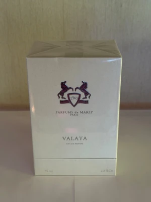 Parfums de Marly Valaya EdP 75ml - Lyxig parfym från Parfums de Marly i modellen Valaya. Flaskan kommer i en elegant, ljusbeige kartong med klassisk logotyp och detaljer i mörkrött. Eau de Parfum, 75 ml. Tillverkad i Frankrike och känd för sin exklusiva doft och stilrena design.