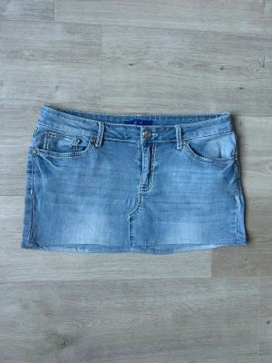 Blå Mini Kjol Skirt Y2K Embroidery Jeanskjol  - Mycket fin kjol i blå färg. Kjolen är i mycket bra skick och sparsamt använda. |  Äkta som allt annat jag säljer! ✅ |  Storlek: XL/42 Skick: Mycket Bra Skick - tyvärr en väldigt liten fläck (SE SISTA BILD) | Färg: Blå | Märke: APT. 9 | Modell: Kjol |   Hör gärna av dig vid frågor så svarar jag så fort jag kan! 😁 |