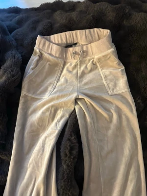 Beige mjukisbyxor från Juicy Couture - Säljer ett set beige mjukisbyxor och kofta från Juicy Couture i storlek M i koftan, storlek S i byxan. Bra skick. Säljer båda för 600kr