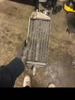 Aluminiumkylare till fordon - Säljer en silverfärgad kylare i aluminium, perfekt för dig som behöver reservdel till bil eller motorcykel. Kylflänsar och rör synliga, robust konstruktion och rektangulär form. Passar för dig som gillar att meka eller bygga om fordon.