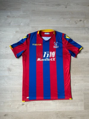 Crystal Palace Fotbollströja 2017/18 Hemmatröja Storlek XXL - Mycket fin fotbollströja i blå färg. Tröjan är i mycket bra skick och sparsamt använda. |  Äkta som allt annat jag säljer! ✅ |  Storlek: XXL | Skick: Mycket Bra Skick - Tyvärr har trycket börjat släppt litegrann på sponsortexten och ett väldigt litet hål på baksidan men inget tydligt (SE SISTA 3 BILDER) | Färg: Blå, röd och gul| Märke: Macron | Modell: Fotbollströja |  Hör gärna av dig vid frågor så svarar jag så fort jag kan! 😄