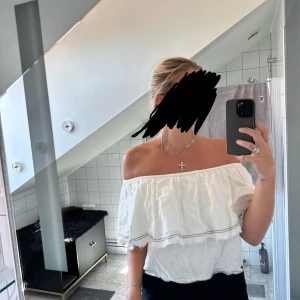 Vit offshoulder linnetopp från Zara - Superfin vit offshoulder topp från Zara i 100% linne. Toppen har volang med råa kanter och svarta sömdetaljer, vilket ger en chill och trendig vibe. 