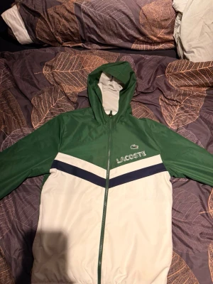 Lacoste Tracksuit  - Säljer en snygg tracksuit från Lacoste med grön och vit färgkombination. Både jackan och byxorna kan säljas seperat för 800kr/st. Tracksuiten är i bra skick och knappt använd !🍀